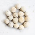 Several white pepper peppercorns close up on gray Royalty Free Stock Photo