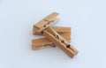 Several wooden clothes pins lying on each other on a white background. Close up