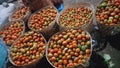 several woven bamboo baskets filled with piles of red and green tomatoes