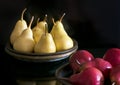 Several yellow and red pears in bowls