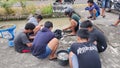 several young Indonesians, cleaning tilapia together