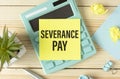 Severance Pay on the table, calculator and paper clips on wooden background