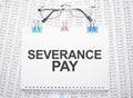 severance pay text written on paper with pen and glasses