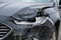 severe front-end damage on black car with shattered headlight and dented hood.. Royalty Free Stock Photo