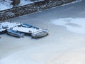 Severe winter. Three small boats frozen in water near by the coast. Frozen river, pond, lake, sea. Royalty Free Stock Photo