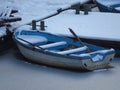 Severe winter. A small blue boat covered with snow frozen in water near by the coast. Frozen river, pond, lake, sea. Royalty Free Stock Photo