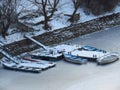 Severe freezing winter. Small boats frozen in water near by the coast. Frozen river, pond, lake, sea. Royalty Free Stock Photo