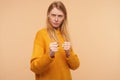 Severe young green-eyed redhead woman with casual hairstyle raising fists in protective gesture and frowning eyebrows while