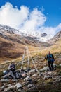 Tourists-photographers have a rest on a mountainside