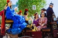 Beautiful women in traditional and colorful dress travelling in a horse drawn carriages at the April Fair, Seville Fair Royalty Free Stock Photo