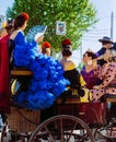 Beautiful women in traditional and colorful dress travelling in a horse drawn carriages at the April Fair, Seville Fair Royalty Free Stock Photo