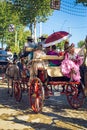 Beautiful woman in traditional and colorful dress travelling in a horse drawn carriages at the April Fair, Seville Fair