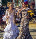 Elegant women dressed in traditional costumes enjoy April Fair , Seville Fair Feria de Sevilla.