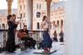 Seville, Spain - April 11, 2023: Flamenco dancer accompanied by street buskers guitarists on the Plaza de EspaÃÂ±a galleries