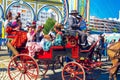 Spanish families in traditional and colorful dress travelling in a horse drawn carriages at the April Fair, Seville Fair Royalty Free Stock Photo