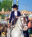 Young Beautiful and Attractive Woman riding andalusian Horse Pure Spanish Horse and celebrating Seville`s April Fair Royalty Free Stock Photo