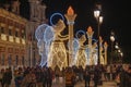 Christmas lights decoration in the shape of an angel holding a torch in from of The Palace of