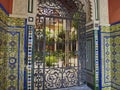 typical spanish patio with wrought iron gate, tiles and flowers