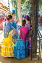 Young Women relaxing and dressed in traditional costumes at the Seville`s April Fair.
