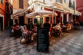 Tourists enjoy food and drinks at a restaurant patio in the Santa Cruz Jewish Quarter district of Seville, Spain