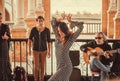 Dancer of traditional flamenco style and band with guitarist and singer on street of Andalusian city