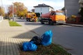 Sewage clearing by special technical means on the streets of a small European town. Orange cars and municipal workers clean the ci