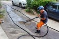 sewer cleaning and worker with water and hose in pipe
