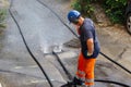 sewer cleaning and worker with water and hose in pipe