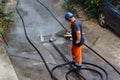 sewer cleaning and worker with water and hose in pipe