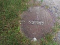 Sewer Cover with Grass and Gravel Royalty Free Stock Photo