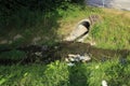 Sewer, drainpipe of concrete leads dirty water in a small brook