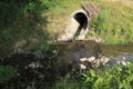 Sewer, drainpipe of concrete leads dirty water in a small brook