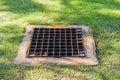 The sewer grate on the lawn. Royalty Free Stock Photo