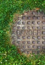 Sewer manhole with grass and word danger Royalty Free Stock Photo