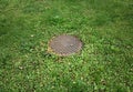 Sewer manhole in the middle of lawn Royalty Free Stock Photo