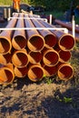 sewer orange pvc pipes stacked on construction site. Royalty Free Stock Photo