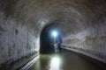 Sewer tunnel worker examines sewer system