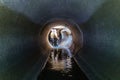 Sewer tunnel workers examines sewer system damage and wastewater leakage