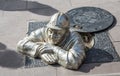 Sewer worker make of metal in the middle of the street smiling at tourists