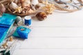 Sewing accessories and basket with sea shells on white wooden surface, space for text Royalty Free Stock Photo