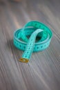 Sewing accessories Ã¢â¬â the green centimetric measuring tape, tailor tape on a wooden background Royalty Free Stock Photo