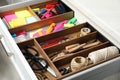 Sewing accessories and stationery in open desk drawer