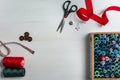 Sewing accessories on a white background. Box with sewing threads and needles, scissors and buttons. Top view, flatlay Royalty Free Stock Photo