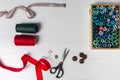 Sewing accessories on a white background. Box with sewing threads and needles, scissors and buttons. Top view, flatlay Royalty Free Stock Photo