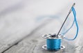 sewing bobbin with blue thread and needle. Royalty Free Stock Photo