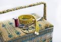 A sewing box with scissors, a tailor`s tape and a spool of red thread on a white background. Royalty Free Stock Photo
