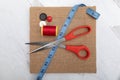 Sewing and craft supplies background red tread spool button blue measuring tape scissors Royalty Free Stock Photo