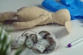 Sewing create of stuffed rabbit toy with needle in body lying on table. Knit hobby. Hare toy near blue polka dot textile