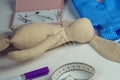 Sewing create of stuffed rabbit toy with needle in body lying on table. Knit hobby. Hare toy near blue polka dot textile