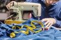 Sewing denim jeans with sewing machine. Repair jeans by sewing machine. Alteration jeans, hemming a pair of jeans, handmade Royalty Free Stock Photo